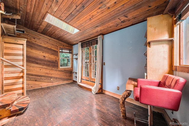 10419 Christopher Dr, Conifer, CO 80433 - sitting room featuring lofted ceiling, wood walls, wood finished floors, a skylight, and baseboards