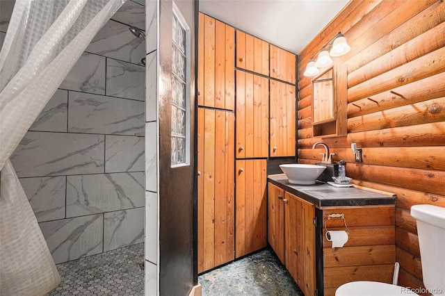 10419 Christopher Dr, Conifer, CO 80433 - bathroom with log walls, toilet, tiled shower, and vanity