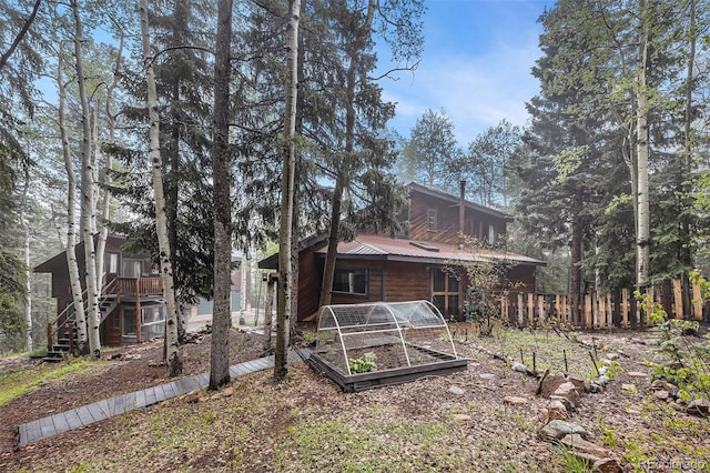 10419 Christopher Dr, Conifer, CO 80433 - rear view of house with a vegetable garden, metal roof, and stairs