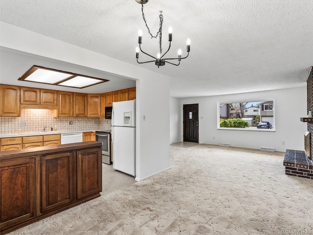 kitchen featuring a sink, open floor plan, a chandelier, light colored carpet, and white appliances