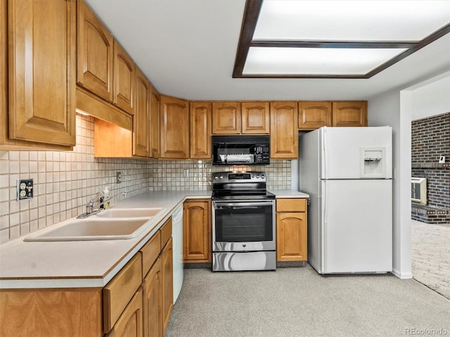 kitchen featuring brown cabinetry, a sink, light carpet, and white appliances