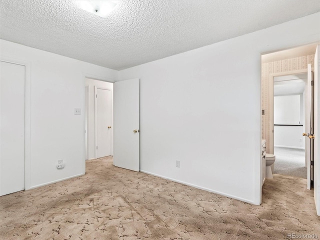 unfurnished bedroom featuring baseboards, carpet floors, and a textured ceiling