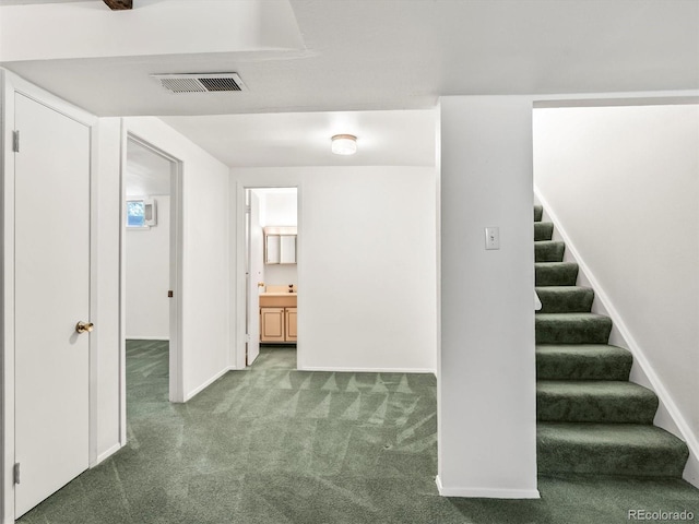 interior space featuring baseboards, visible vents, and carpet
