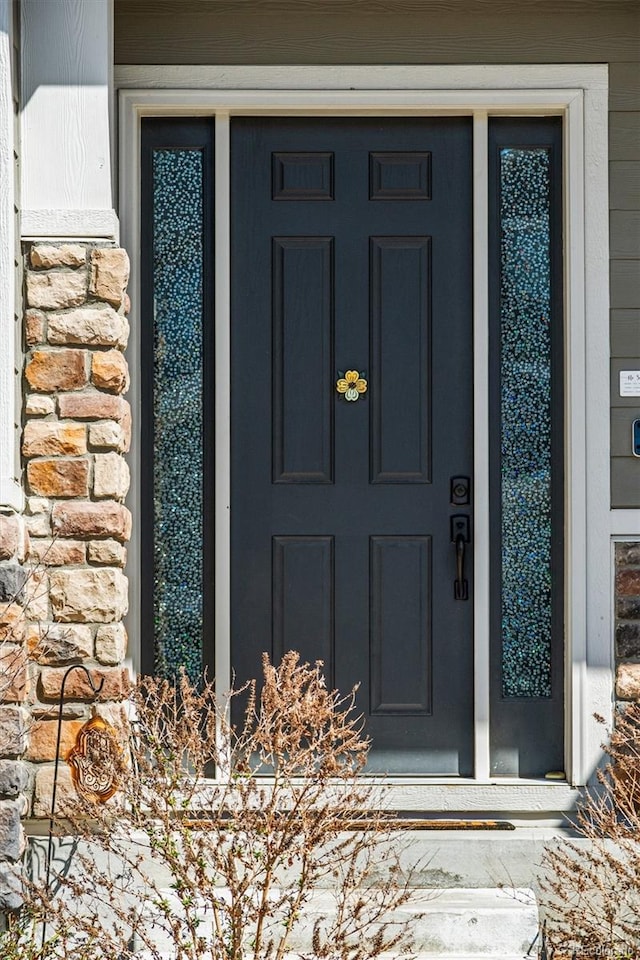 doorway to property featuring stone siding