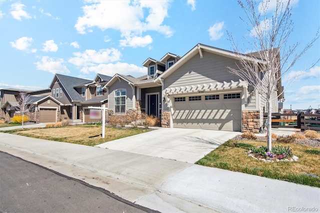 14160 Ivanhoe St, Thornton, CO 80602 - view of front of home featuring stone siding, an attached garage, concrete driveway, and a front yard