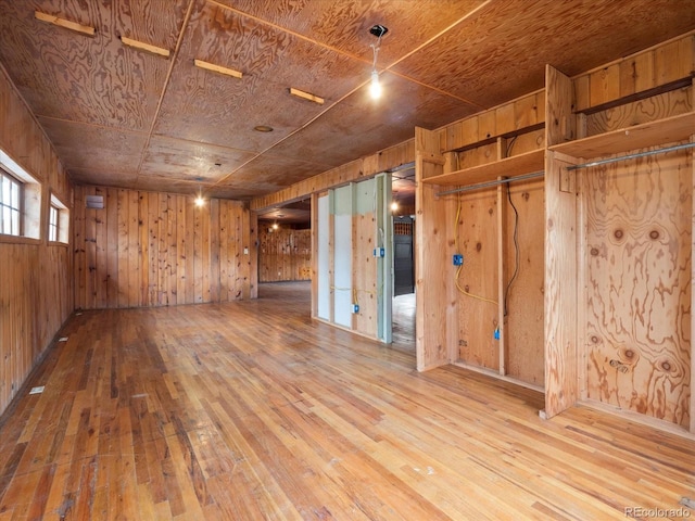 unfurnished room featuring hardwood / wood-style floors, wooden ceiling, and wood walls