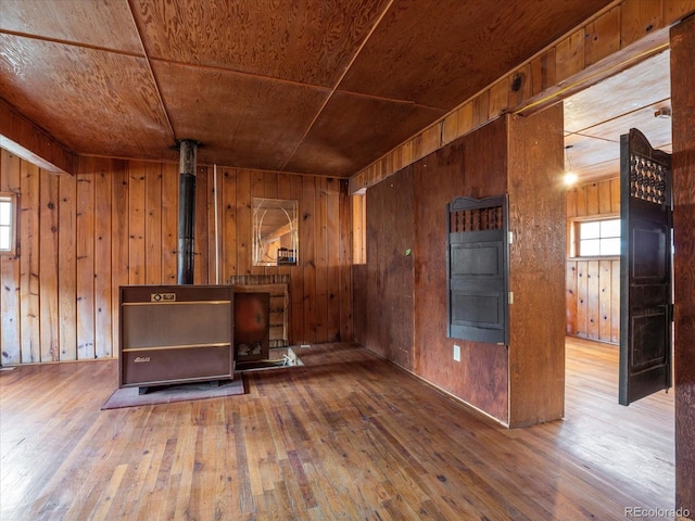 unfurnished living room featuring hardwood / wood-style floors, wooden ceiling, and wooden walls