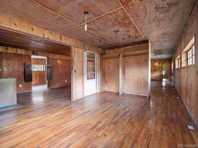 empty room with wood walls, hardwood / wood-style floors, and wooden ceiling