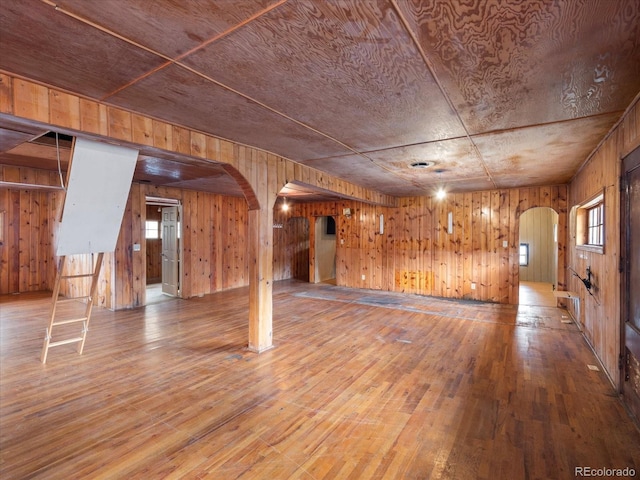 basement featuring hardwood / wood-style floors, plenty of natural light, wood walls, and wood ceiling