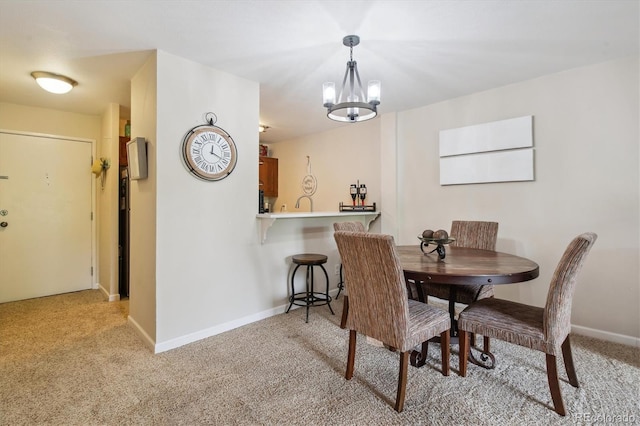 2880 S Locust St Unit 305N, Denver, CO 80222 - dining space featuring light carpet, baseboards, and a chandelier