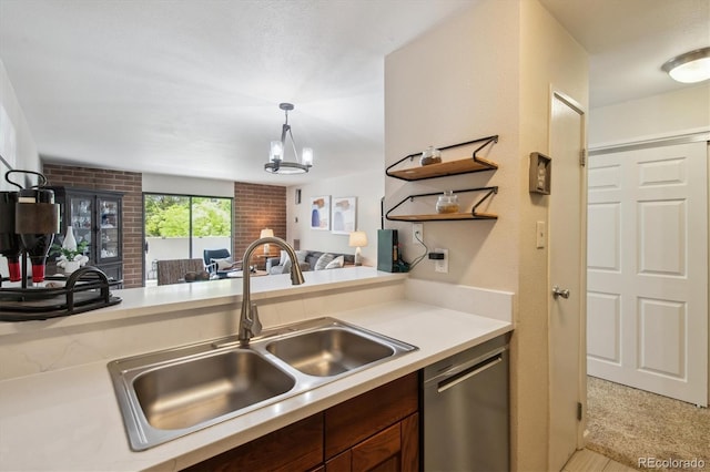 2880 S Locust St Unit 305N, Denver, CO 80222 - kitchen featuring stainless steel dishwasher, a sink, light countertops, open floor plan, and decorative light fixtures