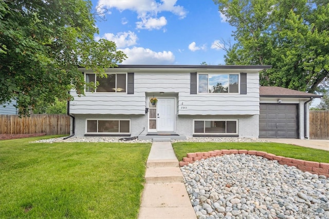2843 S Otis St, Denver, CO 80227 - split foyer home featuring a garage, concrete driveway, and brick siding