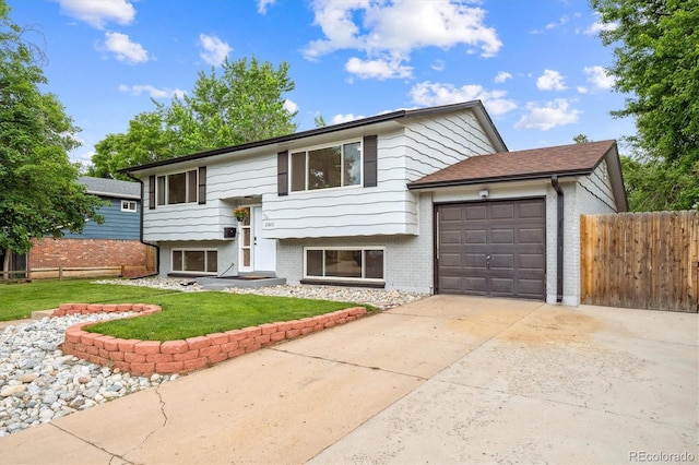 2843 S Otis St, Denver, CO 80227 - raised ranch featuring an attached garage, driveway, and brick siding