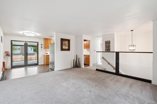 2843 S Otis St, Denver, CO 80227 - carpeted empty room with baseboards and a chandelier