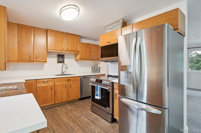 2843 S Otis St, Denver, CO 80227 - kitchen featuring appliances with stainless steel finishes, light countertops, wood finished floors, and brown cabinets