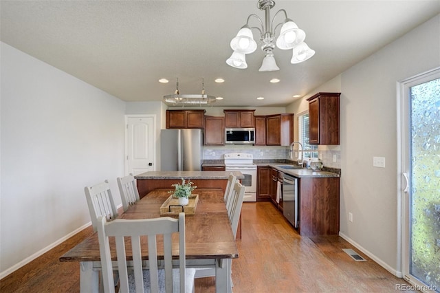2456 Sierra Springs Dr, Colorado Springs, CO 80916 - kitchen featuring stainless steel appliances, a chandelier, light wood-style flooring, plenty of natural light, and recessed lighting