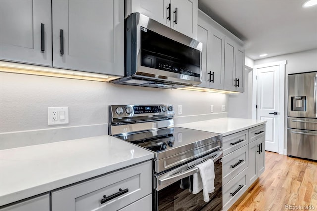 kitchen with stainless steel appliances, recessed lighting, light countertops, and light wood-style floors