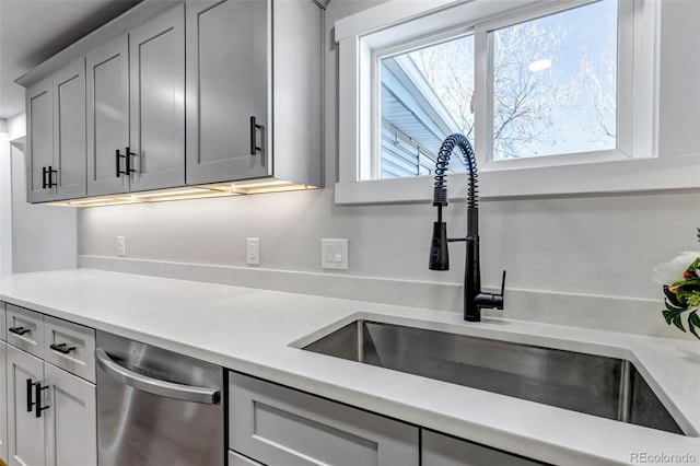 kitchen featuring light countertops, a sink, and stainless steel dishwasher