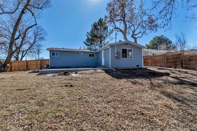 back of property with a fenced backyard and a patio