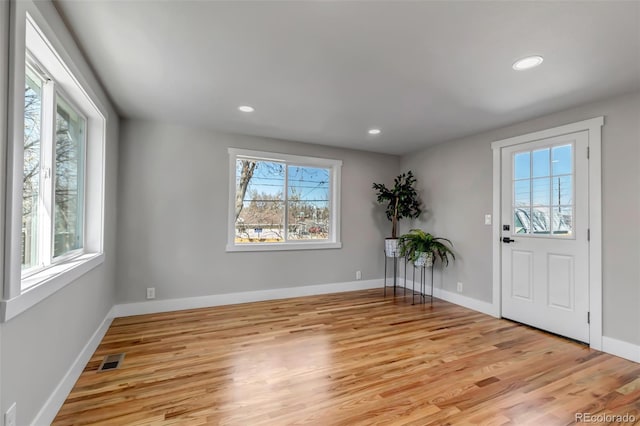 foyer entrance with visible vents, plenty of natural light, and light wood-style flooring