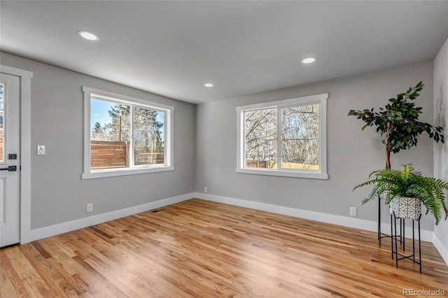 interior space with baseboards, recessed lighting, and light wood-style floors