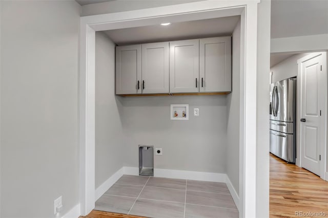 laundry area with cabinet space, baseboards, hookup for a washing machine, hookup for an electric dryer, and light tile patterned flooring