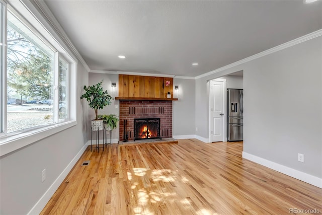 unfurnished living room with a fireplace, visible vents, baseboards, light wood finished floors, and crown molding