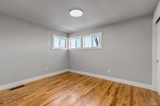 unfurnished room featuring light wood-style floors, baseboards, and visible vents