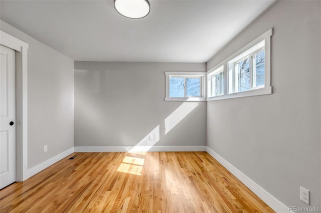 empty room featuring wood finished floors and baseboards