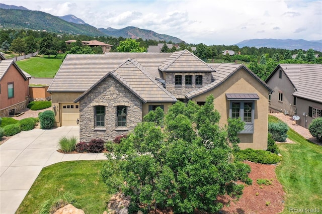 1915 Cantwell Grv, Colorado Springs, CO 80906 - view of front of property featuring stone siding, stucco siding, driveway, a mountain view, and a garage