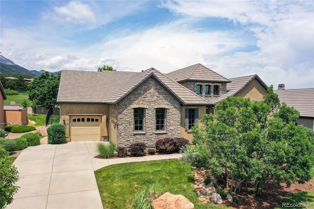 1915 Cantwell Grv, Colorado Springs, CO 80906 - view of front facade featuring concrete driveway, stone siding, stucco siding, and a garage