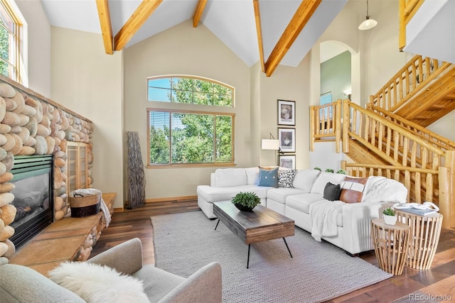 living room with a stone fireplace, dark hardwood / wood-style floors, high vaulted ceiling, and a wealth of natural light