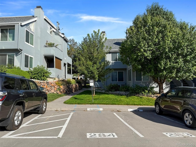 view of car parking featuring a lawn