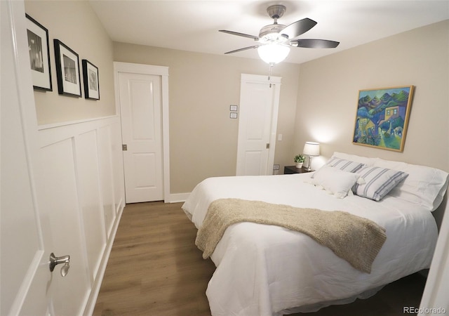 bedroom with dark hardwood / wood-style flooring and ceiling fan