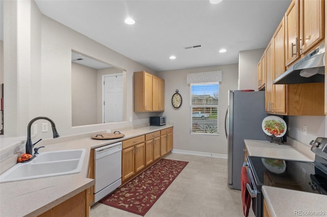 kitchen featuring visible vents, light floors, under cabinet range hood, a sink, and appliances with stainless steel finishes