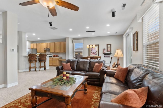 living room with ceiling fan, visible vents, light colored carpet, baseboards, and recessed lighting