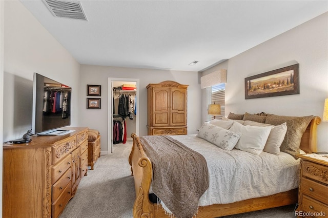 bedroom featuring visible vents, light carpet, a spacious closet, and a closet