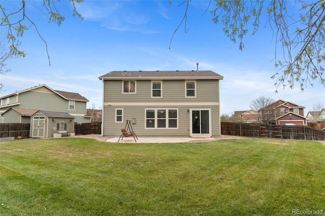 rear view of property featuring a storage unit, a fenced backyard, an outbuilding, a patio area, and a lawn