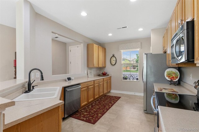 201 Shenandoah Way, Brighton, CO 80603 - kitchen featuring appliances with stainless steel finishes, a sink, recessed lighting, light floors, and light countertops
