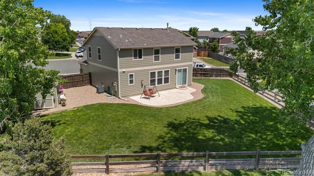 201 Shenandoah Way, Brighton, CO 80603 - back of property with a patio area, central air condition unit, and roof with shingles