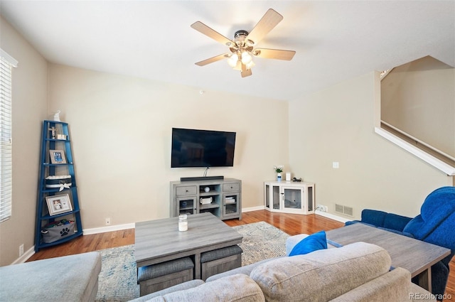 living room featuring wood-type flooring and ceiling fan