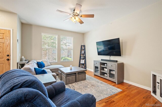 living room featuring wood-type flooring and ceiling fan