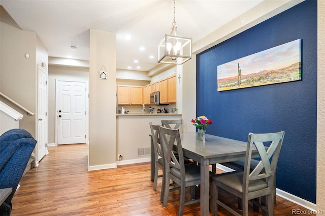 dining room featuring a chandelier and light hardwood / wood-style flooring