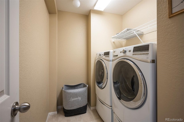 laundry area featuring light tile patterned flooring and washing machine and clothes dryer