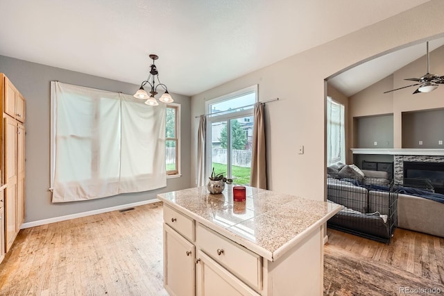 5136 S Ceylon St, Centennial, CO 80015 - kitchen featuring tile countertops, light wood finished floors, arched walkways, hanging light fixtures, and a ceiling fan