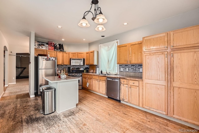 5136 S Ceylon St, Centennial, CO 80015 - kitchen with appliances with stainless steel finishes, backsplash, a kitchen island, recessed lighting, and decorative light fixtures