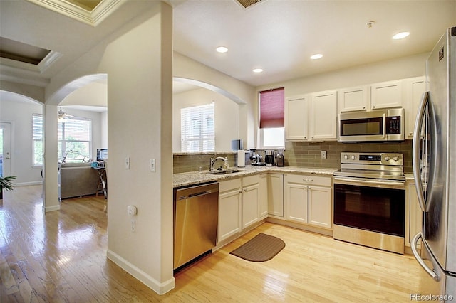 kitchen with stainless steel appliances, a wealth of natural light, a sink, and tasteful backsplash