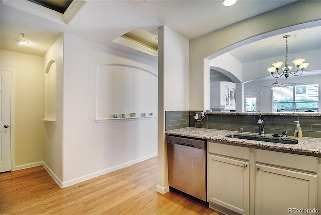 kitchen with decorative backsplash, light wood-style floors, a sink, light stone countertops, and dishwasher