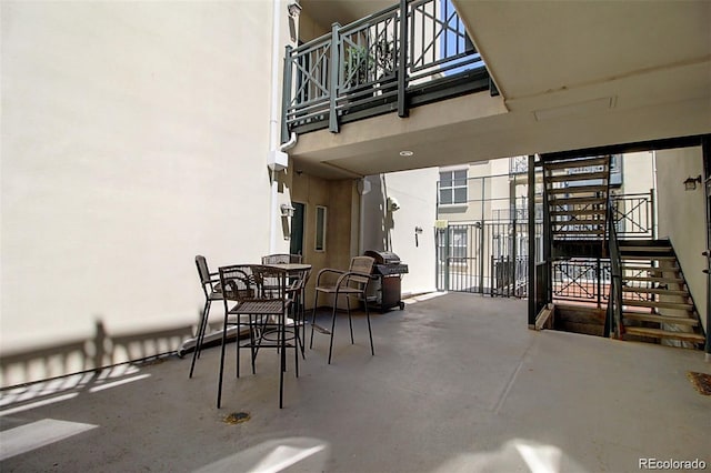 view of patio with stairs, outdoor dining area, and area for grilling