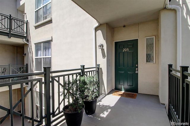 doorway to property with a balcony and stucco siding